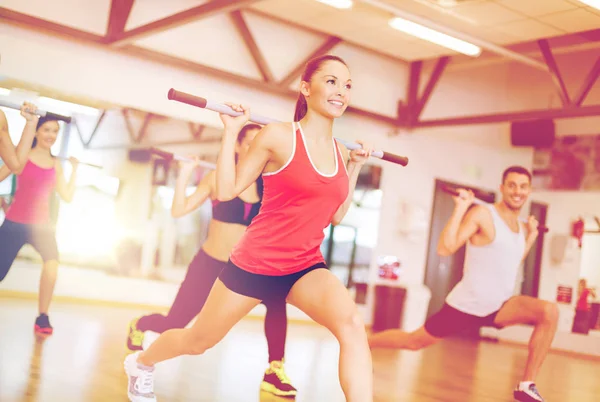 Group of smiling people working out with barbells — Stock Photo, Image