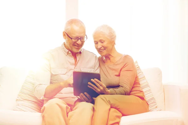 Feliz casal sênior com tablet pc em casa — Fotografia de Stock