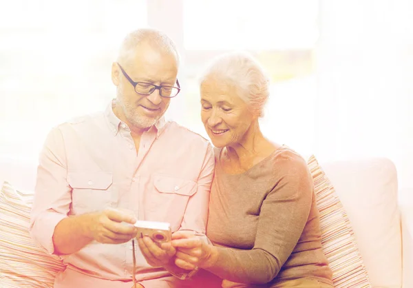 Glückliches Seniorenpaar mit Kamera zu Hause — Stockfoto