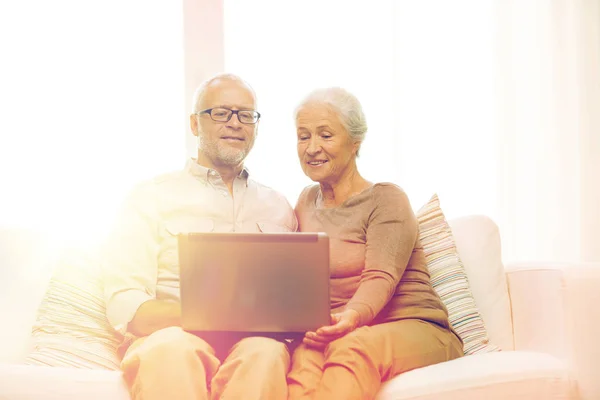 Felice coppia anziana con computer portatile a casa — Foto Stock