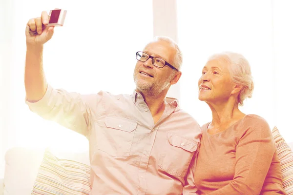 Šťastný starší pár s kamerou doma — Stock fotografie