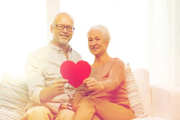 Heureux couple aîné avec forme de coeur rouge à la maison — Photo