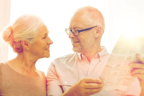 Glückliches Seniorenpaar liest Zeitung zu Hause — Stockfoto