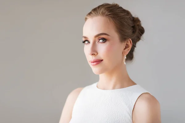 Mulher sorridente em vestido branco com jóias de diamante — Fotografia de Stock