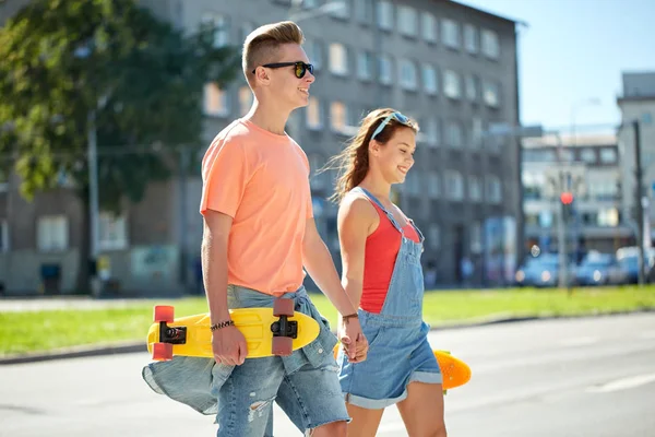 Teenage couple with skateboards on city street — Stock Photo, Image