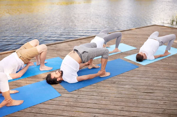 Groep mensen die buiten yoga oefeningen doen — Stockfoto