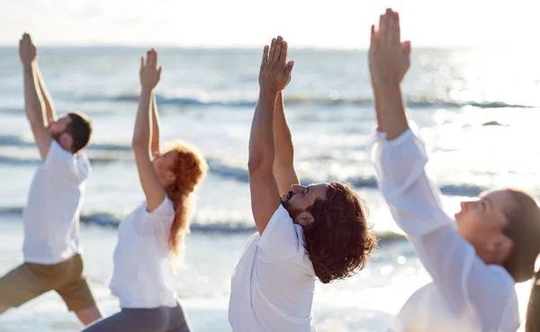 Gruppe von Leuten, die Yoga-Übungen am Strand machen — Stockfoto
