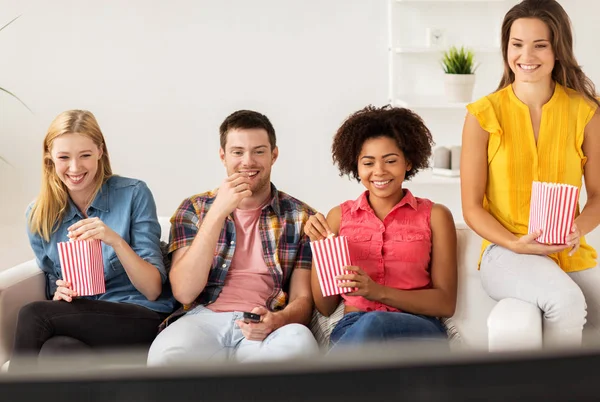 Happy přátelé s popcorn sledování televize u vás doma — Stock fotografie