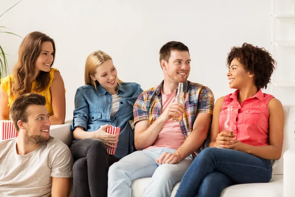 Gelukkige vrienden met popcorn en bier thuis — Stockfoto