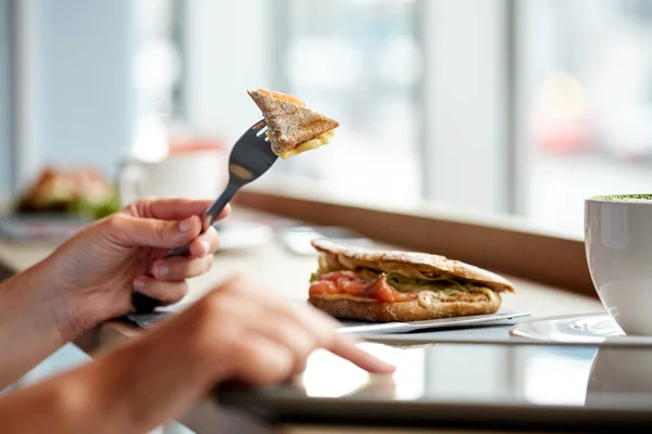 Tablet pc ve panini sandviç kafede kadınla — Stok fotoğraf