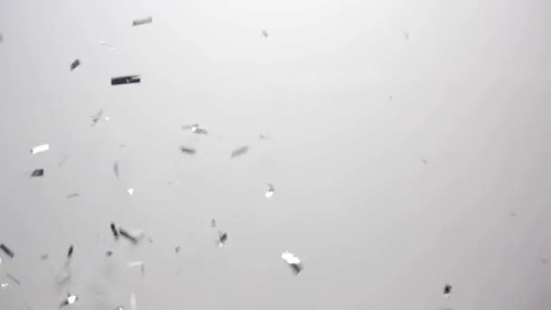 Серебряные конфетти падают на белом фоне — стоковое видео