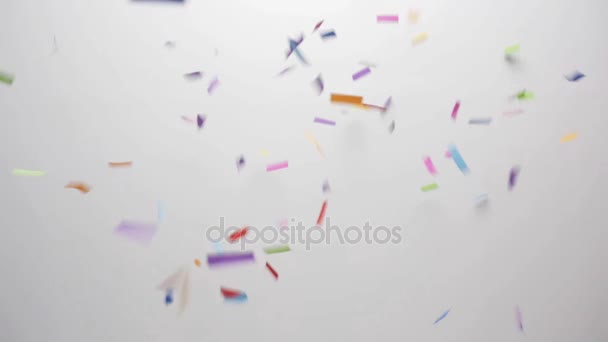 Confetti omvallen op witte achtergrond — Stockvideo