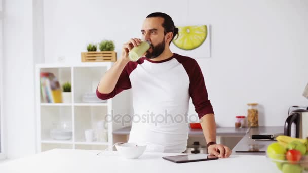 Mannen med TabletPC äter frukost hemma — Stockvideo