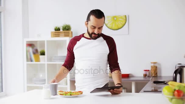 Hombre con la tableta pc desayunar en casa — Vídeos de Stock