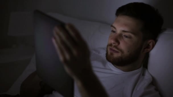 Jovem com tablet pc na cama em casa quarto — Vídeo de Stock