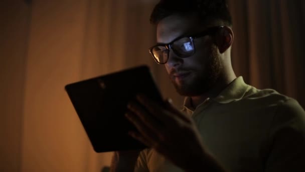 Hombre joven con tableta pc networking en la noche — Vídeo de stock