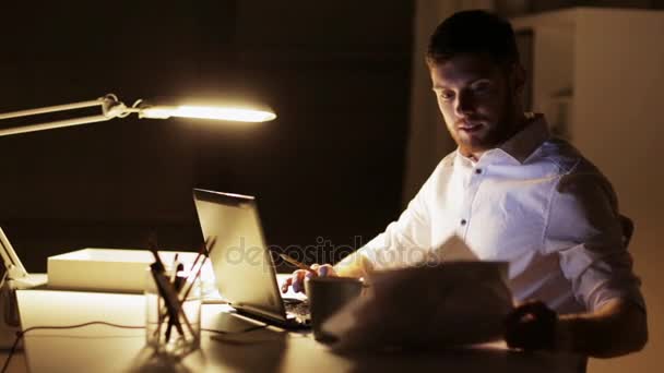 Man with laptop and papers working at night office — Stock Video