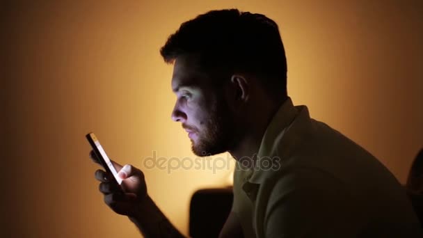 Jonge man met smartphone bij nacht — Stockvideo