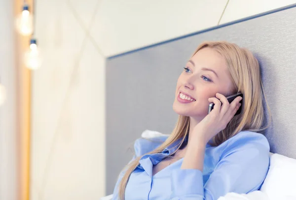 Happy businesswoman with smartphone in hotel room — Stock Photo, Image