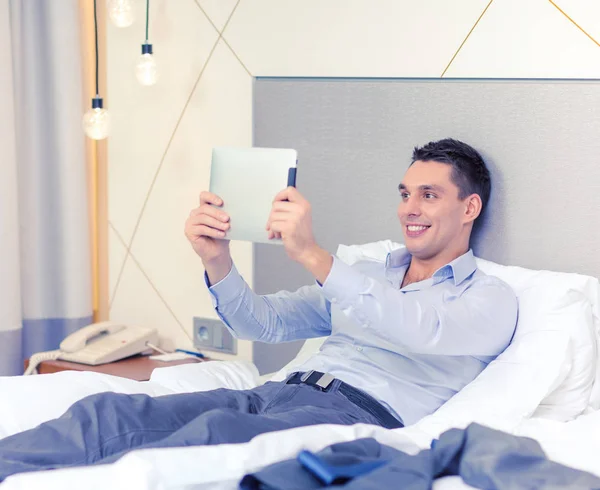 Happy businesswoman with tablet pc in hotel room — Stock Photo, Image