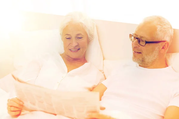 Щаслива старша пара з газетою в ліжку — стокове фото