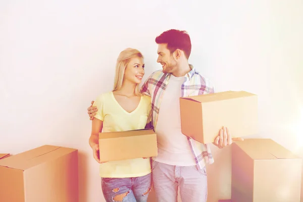 Sonriente pareja con grandes cajas moviéndose a nuevo hogar — Foto de Stock