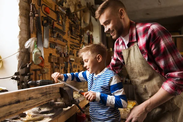 Far och son med rasp arbetar på verkstad — Stockfoto