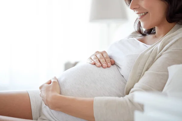 Närbild på glad gravid kvinna i sängen hemma — Stockfoto