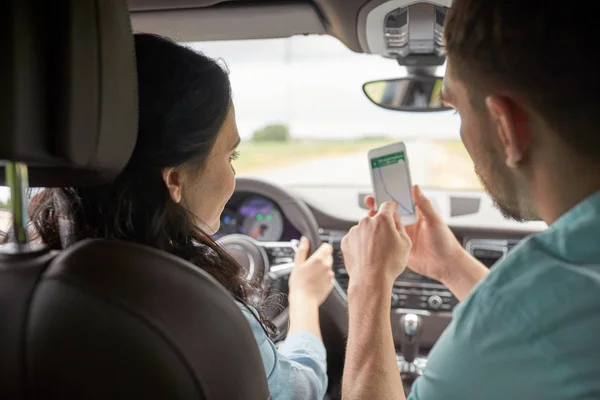 Hombre y mujer felices con smartphone conduciendo en coche —  Fotos de Stock