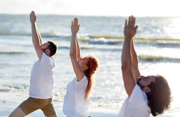 Group of people making yoga exercises on beach — Stock Photo, Image