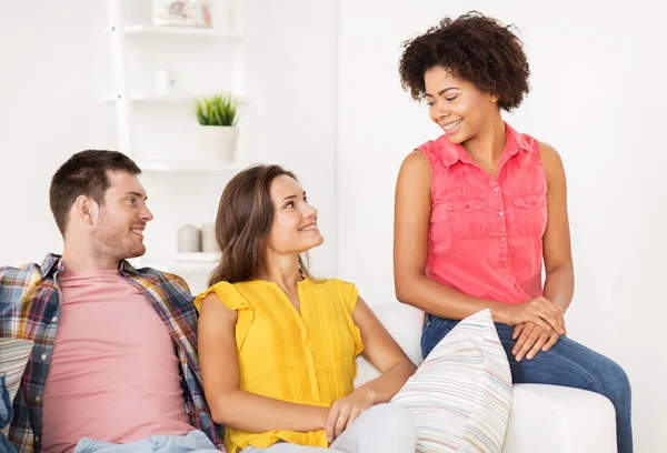 Grupo de amigos felices hablando en casa — Foto de Stock