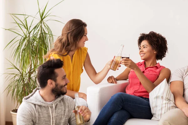 Glada vänner spottar flaskor öl hemma — Stockfoto