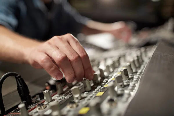 Uomo che utilizza la console di miscelazione in studio di registrazione musicale — Foto Stock