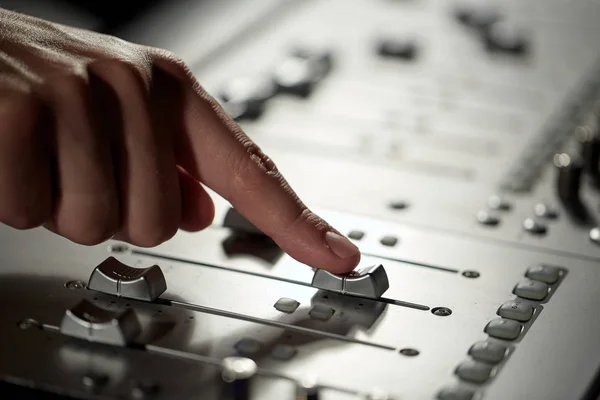 Mano con console di miscelazione in studio di registrazione musicale — Foto Stock