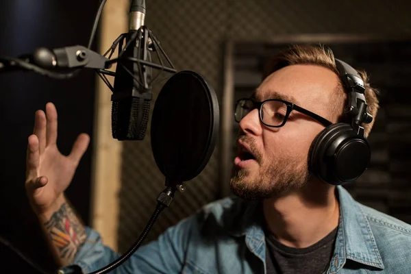 Mann mit Kopfhörer singt im Tonstudio — Stockfoto