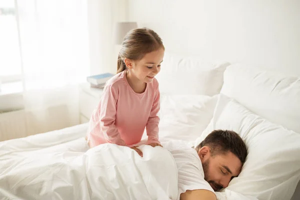 Malá holčička probudit spící otec v posteli — Stock fotografie