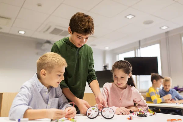 Gelukkige kinderen bouwen robots op robotica school — Stockfoto