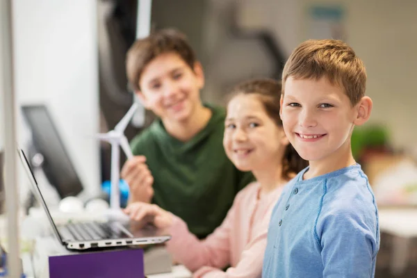 Dzieci z laptopa i wiatr turbina w szkole — Zdjęcie stockowe