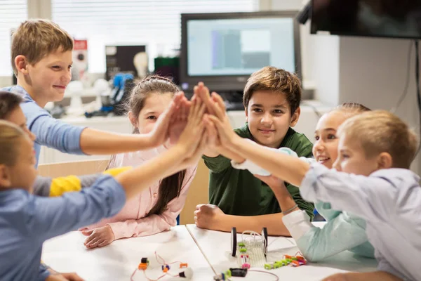 Gelukkige kinderen maken hoge vijf op robotica school — Stockfoto