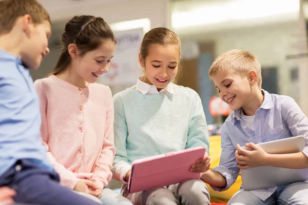 Groep gelukkige kinderen met tablet pc op school — Stockfoto