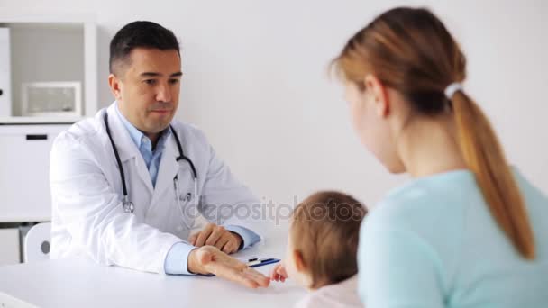 Lachende arts en vrouw met baby bij kliniek — Stockvideo