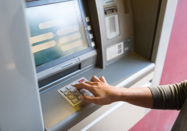 close up of hand entering pin code at atm machine clipart