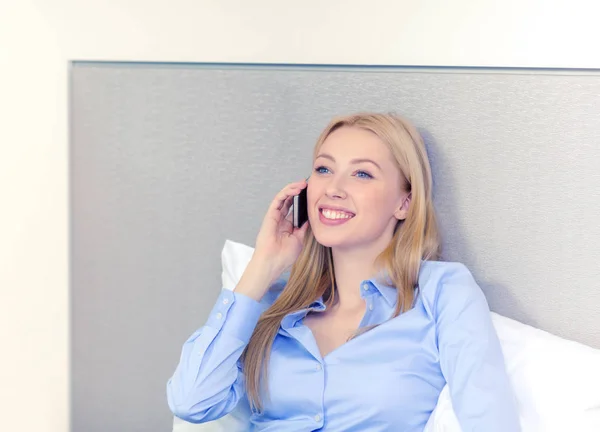 Feliz mujer de negocios con teléfono inteligente en la habitación de hotel —  Fotos de Stock