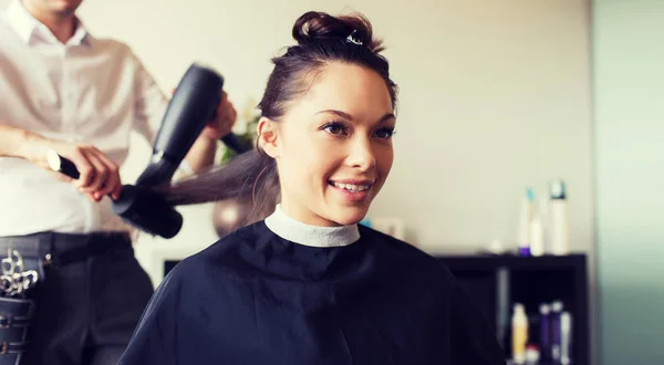 Щаслива жінка зі стилістом робить зачіску в салоні — стокове фото