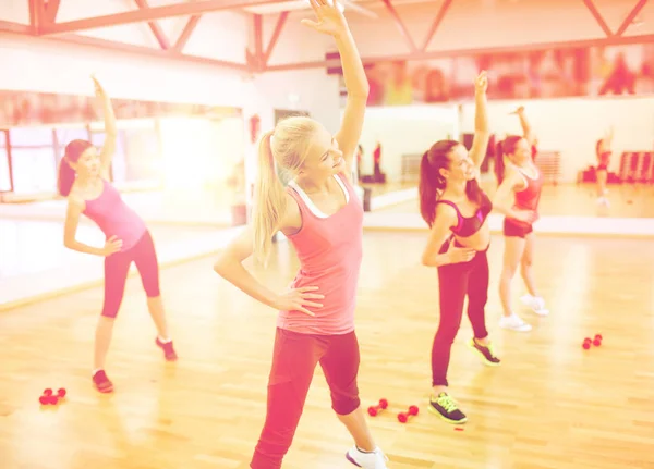 Grupp leende kvinnor stretching i gymmet — Stockfoto