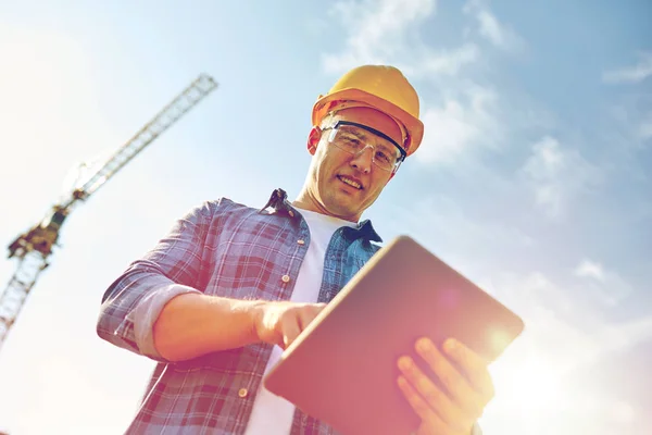 Builder i hardhat med TabletPC på konstruktion — Stockfoto