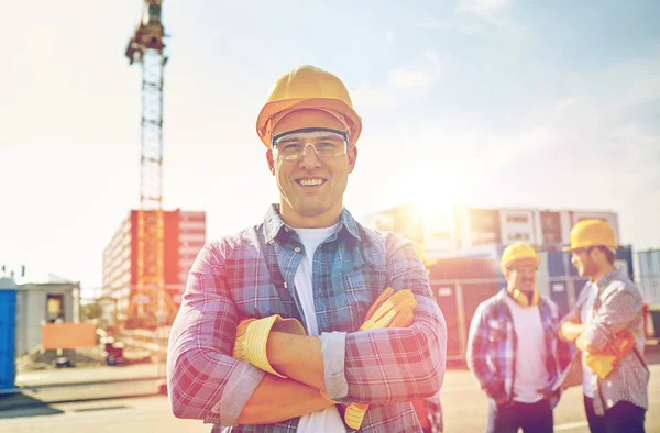 Grupo de constructores sonrientes en hardhats al aire libre —  Fotos de Stock