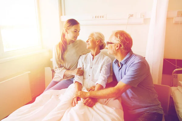 Famille heureuse visitant femme âgée à l'hôpital — Photo