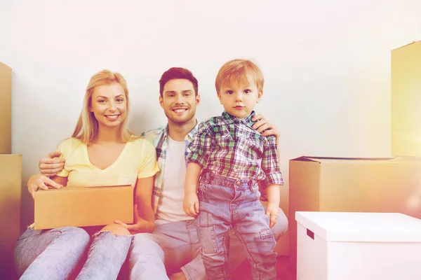 Счастливая семья с коробками переезжает в новый дом — стоковое фото