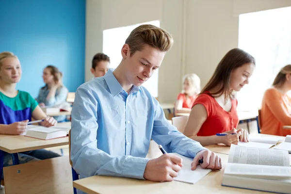 Grupo de estudiantes con la prueba de escritura de libros de la escuela —  Fotos de Stock